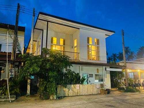 a white house with a tree in front of it at Villa Wonderworld Resort in Ban Nua