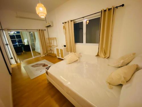 a large white bed in a room with a window at Villa Wonderworld Resort in Ban Nua