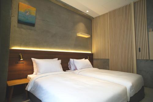 a bedroom with two beds with white pillows at FFF Hotel in Hengchun