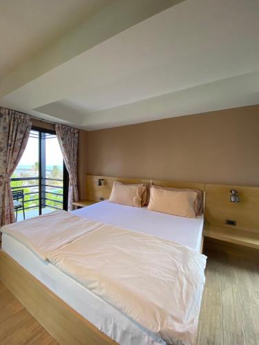 a bedroom with a large white bed and a window at Huahin Place Guest House in Hua Hin