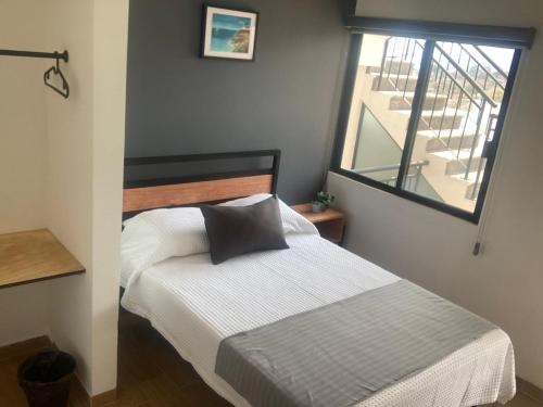 a small bedroom with a bed and a window at Condominio cerca salida norte Lomas de Cocoyoc in Texcalpan