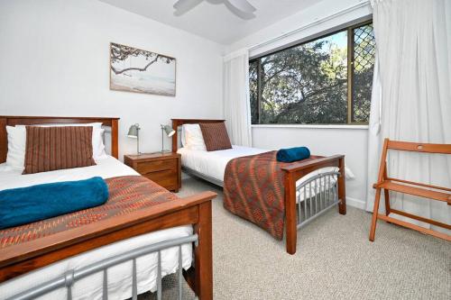 una camera da letto con due letti e una finestra di Mooloolaba Tranquil Hideaway a Mooloolaba