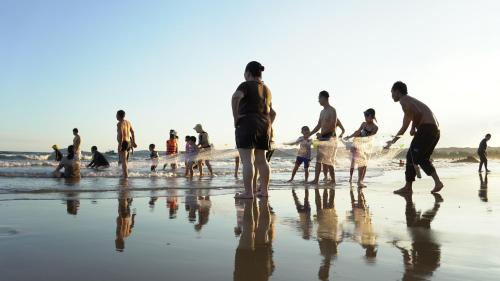 a group of people standing on the beach at Stop And Go Lang Chai Boutique Resort in Phan Thiet