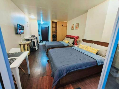 een slaapkamer met twee bedden en een bureau erin bij Baguio Condotel - City Center in Baguio