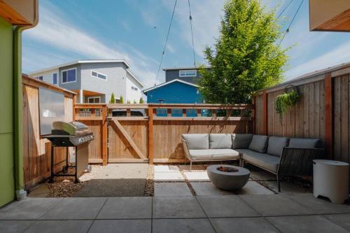 a patio with a couch and a grill on a fence at Haven at Greenbridge Close to Airport and Downtown in Seattle