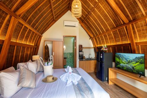 a bedroom with a bed with a flat screen tv at Abian Klumpu Villa & Spa Sanur Bali in Sanur