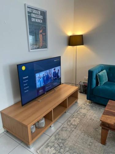 a living room with a flat screen tv and a blue couch at Large and stylish Townhouse in chic area in Brisbane