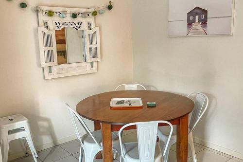 a dining room table with chairs and a book on it at Large and stylish Townhouse in chic area in Brisbane