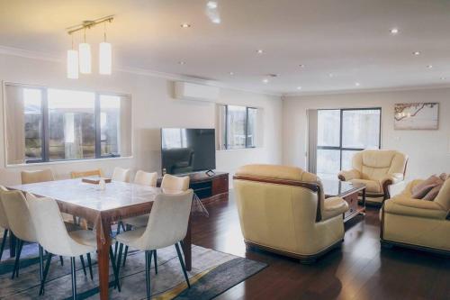 Μια τηλεόραση ή/και κέντρο ψυχαγωγίας στο Hillsborough Spacious 3BR with Ensuite -12mins frm Airport