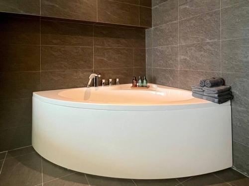 a bath tub in a bathroom with a sink at Janet PentHouse - WestLake - by LioHousing in Hanoi