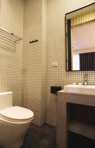 a bathroom with a toilet and a sink and a mirror at FFF Hotel in Hengchun