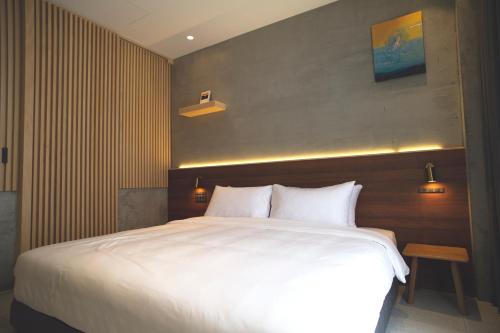 a bedroom with a large bed with white sheets at FFF Hotel in Hengchun