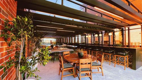a restaurant with tables and chairs and a brick wall at Airali 1 - Apartamento en el centro - Zona 10 de la Ciudad de Guatemala in Guatemala