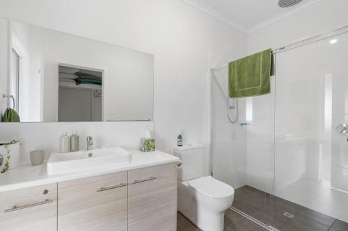 Un baño con inodoro, lavabo y ducha. en 7 Passatt St, Encounter Bay, en Encounter Bay