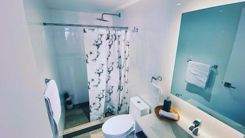 a bathroom with a shower curtain and a toilet at Airali 1 - Apartamento en el centro - Zona 10 de la Ciudad de Guatemala in Guatemala
