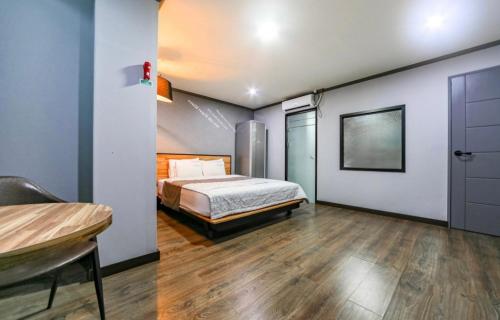 a bedroom with a bed and a table in it at The Sharp Hotel in Changwon