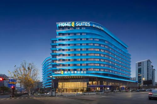 杭州市にあるHome2 Suite by Hilton Hangzhou East Railway Stationの家とスイートの看板がついた青い建物