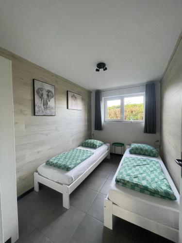 a room with two beds and a window at Luxe vakantiehuis met omheinde tuin voor hond en kinderen in Dirkshorn