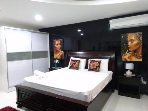 a bedroom with a large bed with a black wall at Jack Kandi Grosvenor Square in Angeles
