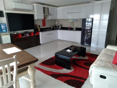 a living room with a table and a kitchen at Jack Kandi Grosvenor Square in Angeles