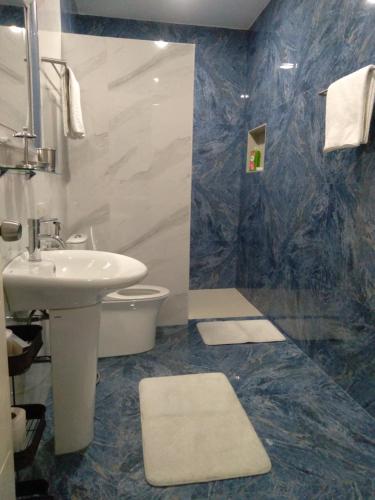 a bathroom with a sink and a toilet at Jack Kandi Grosvenor Square in Angeles