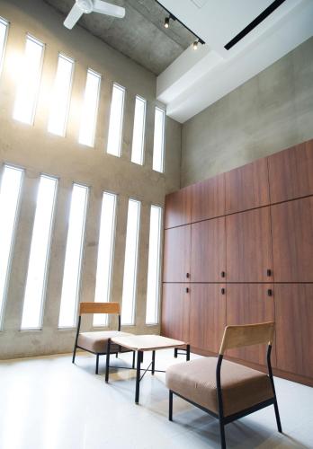 a room with two chairs and a table and some windows at FFF Hotel in Hengchun