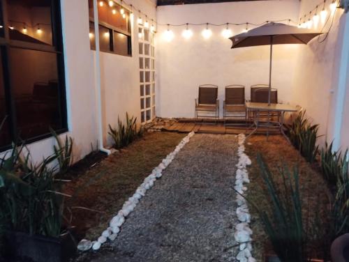 a patio with a table and chairs and an umbrella at Posada Pantitlán in Mexico City