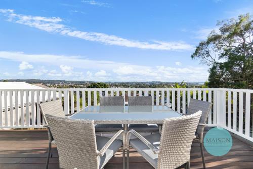 a patio with a table and chairs on a deck at Charming Merewether Cottage in Merewether