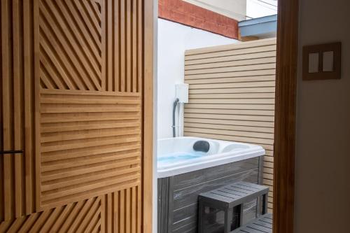 a bathroom with a sink and a wooden wall at The Boardwalk Hotel in San Diego