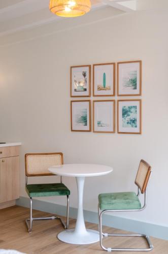 a table and two chairs with a table and pictures on the wall at The Boardwalk Hotel in San Diego