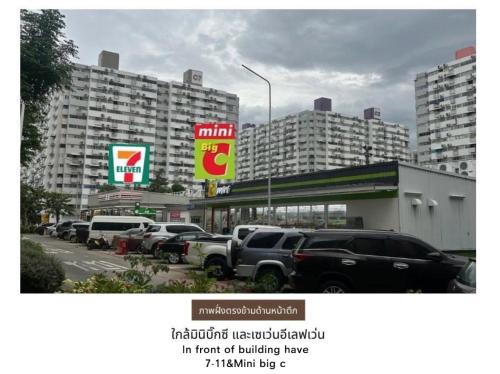 a parking lot with cars parked in front of buildings at Muangthong p2 in Ban Song Hong