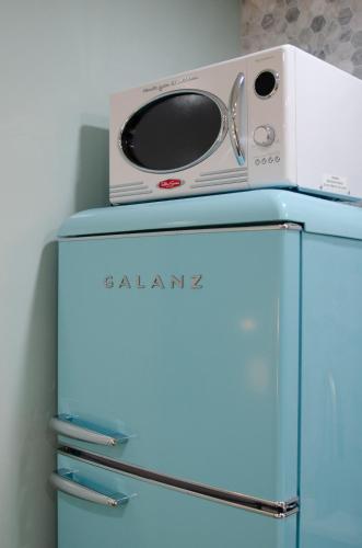 a microwave on top of a blue refrigerator at The Boardwalk Hotel in San Diego