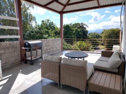 a patio with a grill and chairs and a table at Aparta-Hotel Carmela #2 in Siguatepeque