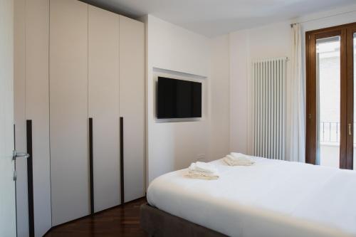 a white bedroom with a bed and a tv at Residential lifestyle in Fano