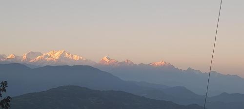 a view of a mountain range with mountains in the background at Hamro Ghar Farmstay in Darjeeling