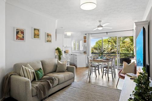 a living room with a couch and a table at Coastal 1-Bed Apartment with Pool & Tennis Court in Gold Coast
