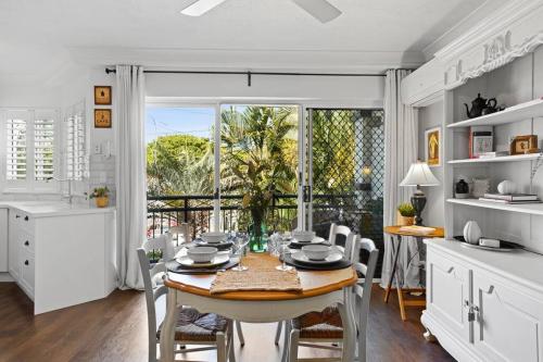 a kitchen and dining room with a table and chairs at Coastal 1-Bed Apartment with Pool & Tennis Court in Gold Coast