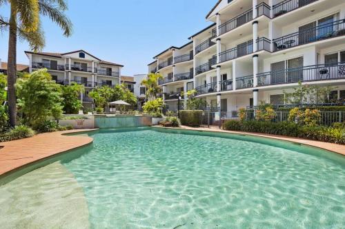 a swimming pool in front of a apartment building at Coastal 1-Bed Apartment with Pool & Tennis Court in Gold Coast