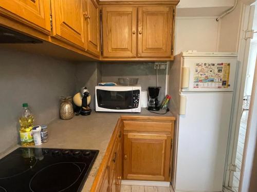 eine Küche mit einer weißen Mikrowelle und einem Kühlschrank in der Unterkunft Miramar By Bellavista - 250 m de la plage - terrasse in Argelès-sur-Mer