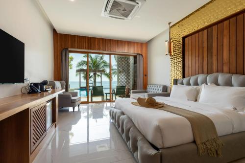 ein Hotelzimmer mit einem großen Bett und einem Fernseher in der Unterkunft Hotel Villa AoKhanom Beachfront in Khanom