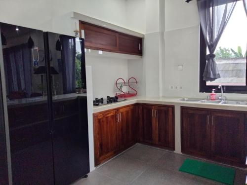 a kitchen with wooden cabinets and a sink at Villa Casablanca in Montongbuwoh