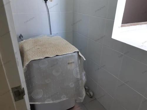 a small bathroom with a toilet in the corner at Erin's Homestay in Labuan