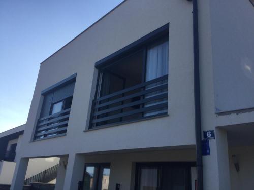 a white building with two windows on the side of it at Appartements VIR in Vir