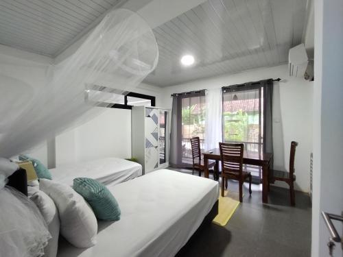 a bedroom with two beds and a table and chairs at Rumah Casablanca in Montongbuwoh