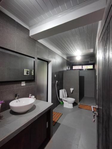 a bathroom with a sink and a toilet at Rumah Casablanca in Montongbuwoh