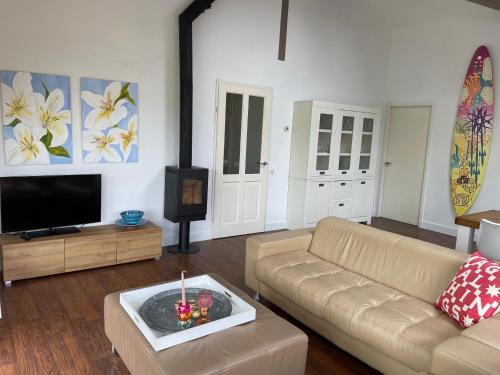 a living room with a couch and a television at StarVilla M in Makkum