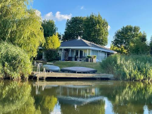 a house on a dock next to a body of water at StarVilla M in Makkum