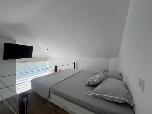 a bedroom with a bed and a flat screen tv at Apartmani Vivami in Budva