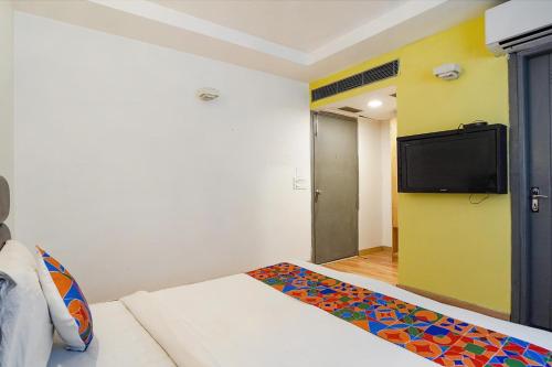 a room with a bed and a flat screen tv at FabHotel Kaushambi in Ghaziabad