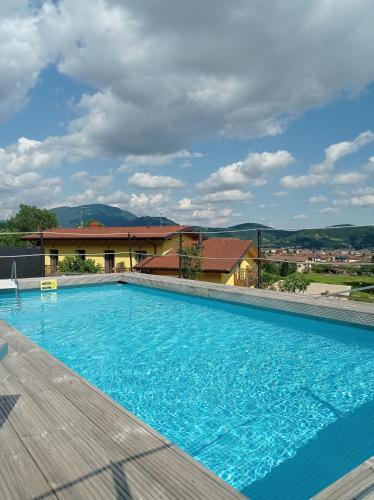 a large blue swimming pool with a building in the background at Agriturismo La Soglia Del Parco in Ranica